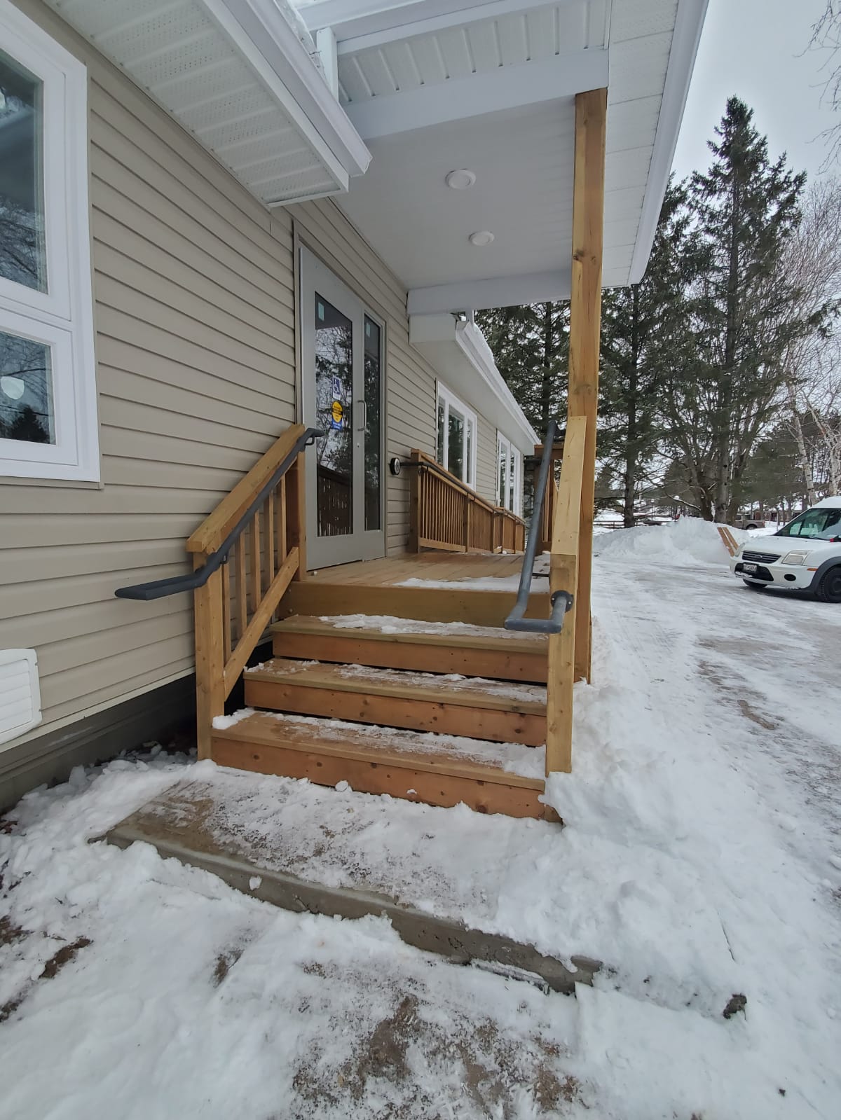 Newly constructed wooden entrance stairs with handrails leading to the daycare facility.