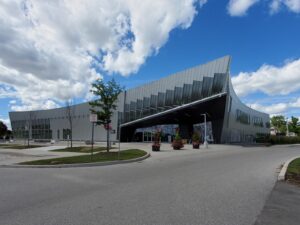 Image of the modernized exterior of the Chancellor Community Centre in Vaughan, featuring a sleek metallic façade, large windows, and landscaped entrance with potted plants, restored by ICON Restoration.