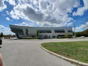 Image of the modern Civic Centre Resource Library exterior in Vaughan, featuring a sleek metallic façade with large windows, landscaped surroundings, and a curved driveway, restored by ICON Restoration.