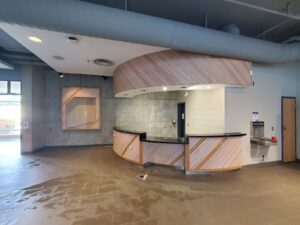 Modern City Playhouse Theatre ticket booth in Vaughan with sleek wooden paneling, LED lighting, and barrier-free design, showcasing accessibility upgrades for a vibrant community hub.