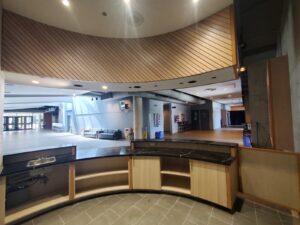 Modern lobby counter at City Playhouse Theatre in Vaughan with a black marble surface, wooden paneling, and recessed lighting, showcasing recent upgrades to the cultural venue.