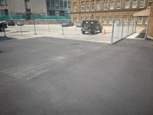 Image of Canada’s Historic Places Riverwood, a historic stone building with shingled roofs, multiple chimneys, and well-maintained gardens, surrounded by lush greenery and a paved driveway.