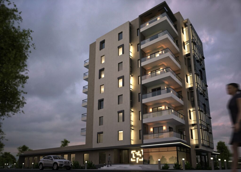 A multi-story modern apartment building with illuminated balconies and windows, surrounded by trees and a car parked nearby.